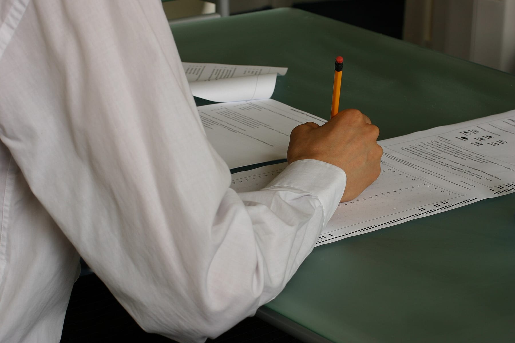 Student writing a timed exam in a classroom